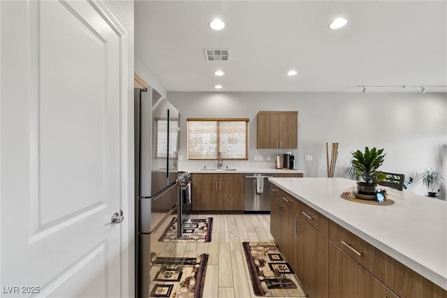 kitchen featuring recessed lighting, appliances with stainless steel finishes, light countertops, a sink, and visible vents