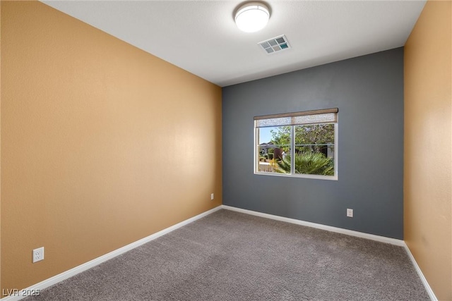 carpeted spare room featuring baseboards and visible vents