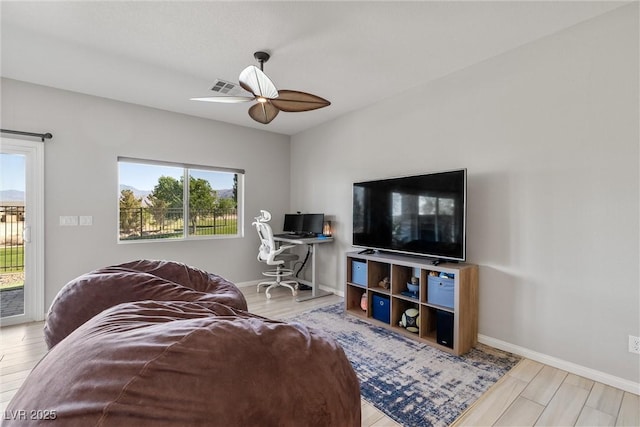 living area featuring ceiling fan, baseboards, wood finished floors, and visible vents