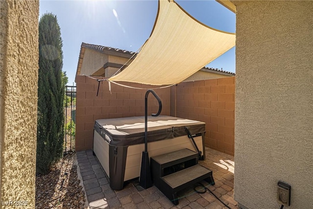 view of patio / terrace with fence and a hot tub
