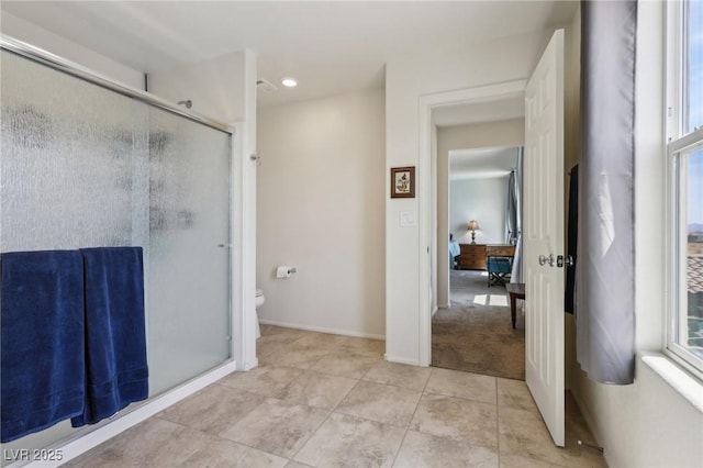 full bathroom with tile patterned floors, a wealth of natural light, toilet, and a shower stall