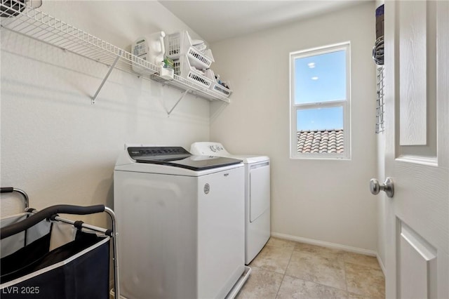 clothes washing area with washer and clothes dryer, baseboards, and laundry area
