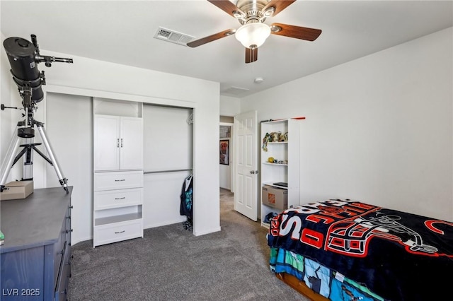 bedroom featuring dark carpet, visible vents, a ceiling fan, and a closet