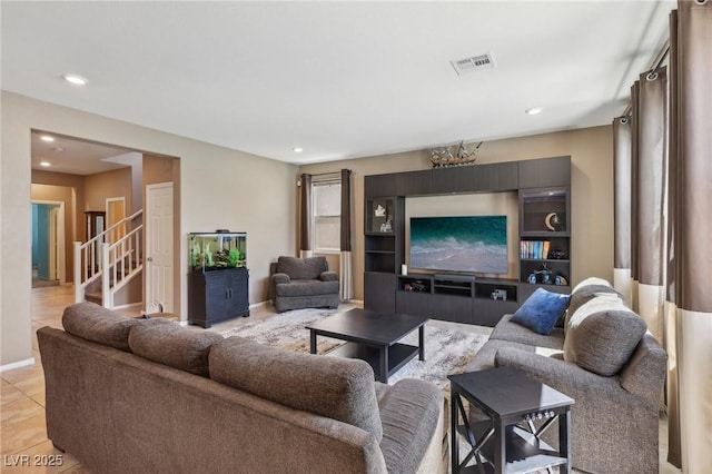 living room featuring light tile patterned floors, visible vents, baseboards, recessed lighting, and stairs