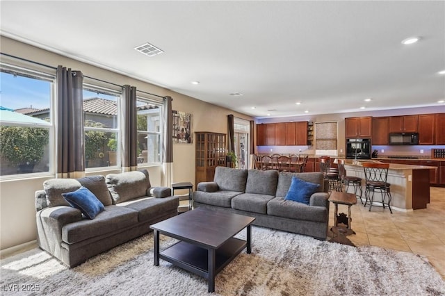living area with visible vents, light tile patterned flooring, and recessed lighting