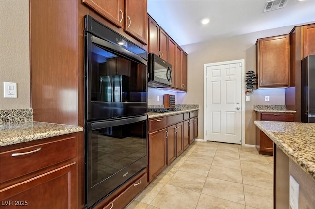 kitchen featuring black appliances, light tile patterned floors, visible vents, and light stone counters