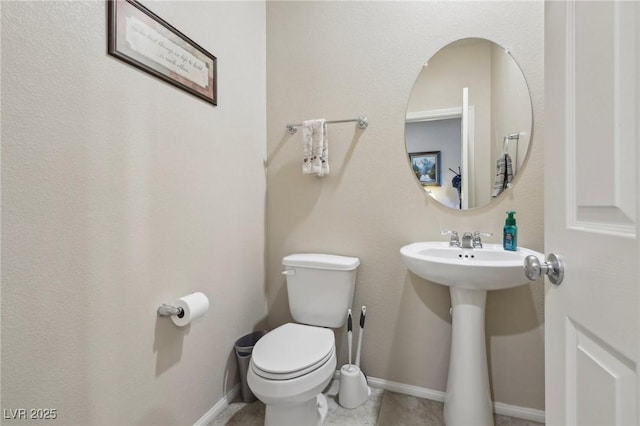 bathroom with toilet and baseboards