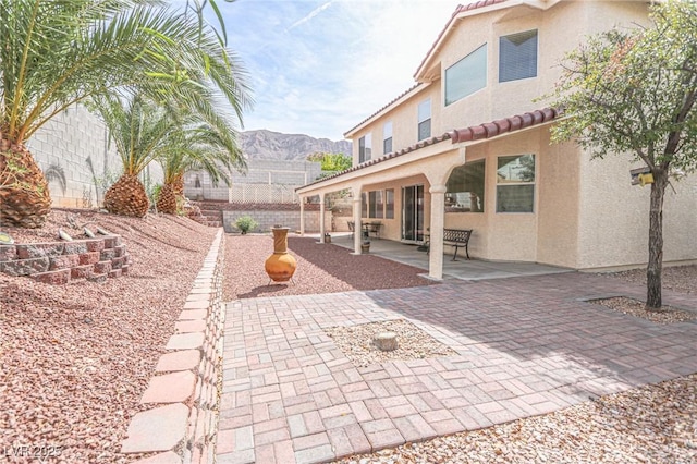 view of patio featuring a mountain view and fence