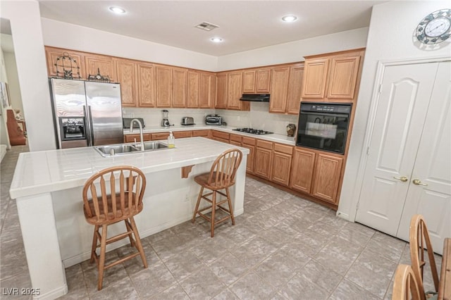 kitchen featuring a sink, stainless steel fridge with ice dispenser, gas cooktop, visible vents, and oven