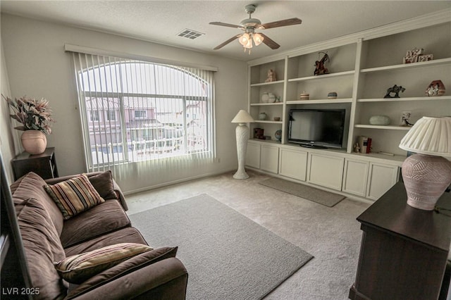 living area featuring light carpet, visible vents, ceiling fan, and a textured ceiling