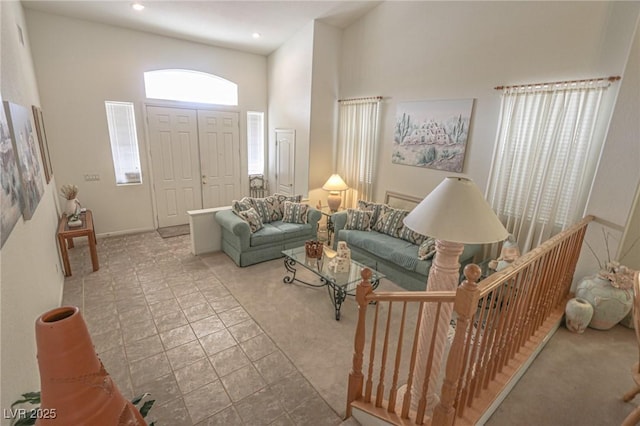 living area featuring a towering ceiling and recessed lighting