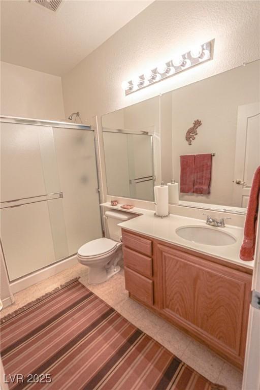 full bath with vanity, toilet, tile patterned flooring, and a shower stall