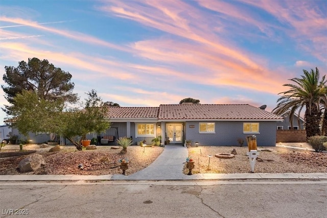 single story home featuring french doors and a tiled roof