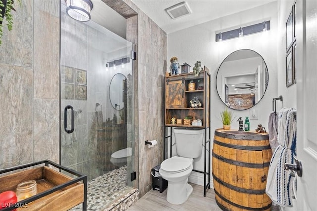 bathroom featuring visible vents, a stall shower, wood finished floors, vanity, and toilet