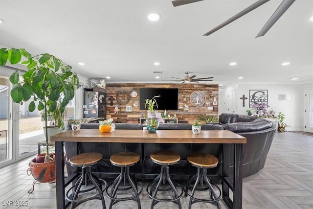 bar with recessed lighting, freestanding refrigerator, ceiling fan, and ornamental molding