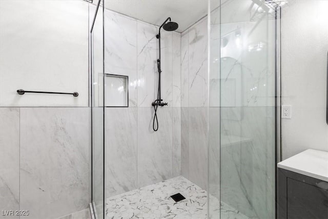 full bath with vanity and a marble finish shower