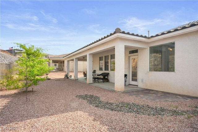 3491 Cottage Thistle Dr, Laughlin, NV 89029 - rear view of house with a tile roof, stucco siding, fence, and a patio area