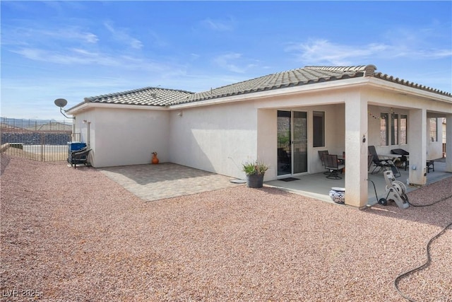 3491 Cottage Thistle Dr, Laughlin, NV 89029 - back of property with a tile roof, stucco siding, fence, and a patio