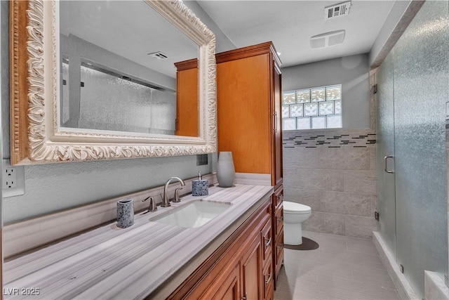 4678 Saddle Pl, Las Vegas, NV 89119 - bathroom with vanity, toilet, a stall shower, tile patterned flooring, and tile walls