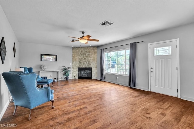 4678 Saddle Pl, Las Vegas, NV 89119 - living area featuring ceiling fan, wood finished floors, a large fireplace, and baseboards