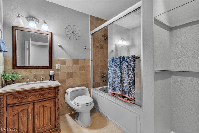 4678 Saddle Pl, Las Vegas, NV 89119 - full bathroom with vanity, toilet, combined bath / shower with glass door, tile walls, and a textured wall