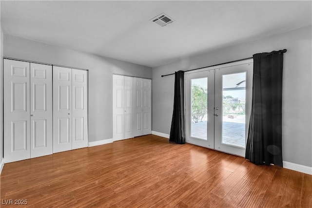 4678 Saddle Pl, Las Vegas, NV 89119 - unfurnished bedroom with access to outside, two closets, wood finished floors, baseboards, and french doors