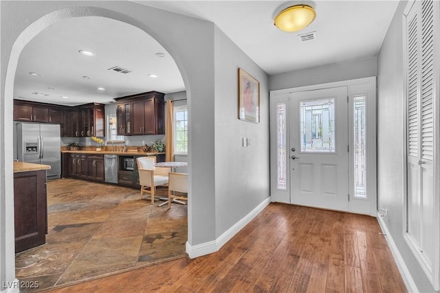 4678 Saddle Pl, Las Vegas, NV 89119 - foyer entrance featuring arched walkways, baseboards, dark wood-style floors, and recessed lighting