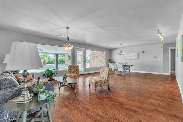 4678 Saddle Pl, Las Vegas, NV 89119 - living area with wood finished floors, baseboards, a chandelier, and a textured ceiling
