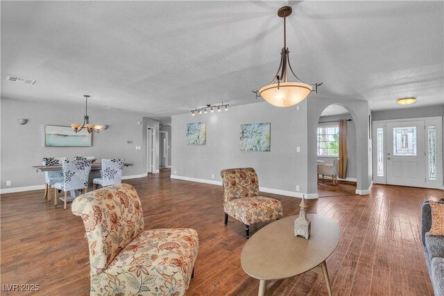 4678 Saddle Pl, Las Vegas, NV 89119 - living area with arched walkways, a chandelier, wood finished floors, and baseboards