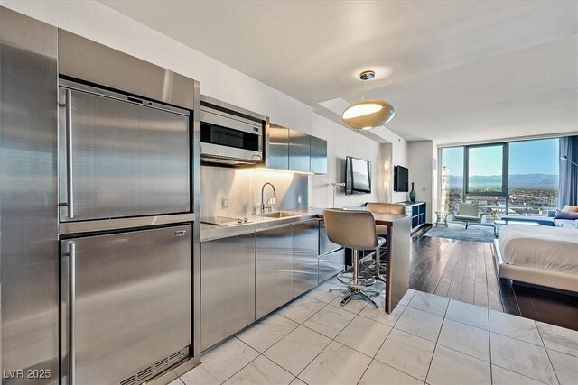 4381 W Flamingo Rd Unit 1609, Las Vegas, NV 89103 - kitchen featuring open floor plan, floor to ceiling windows, a sink, built in appliances, and modern cabinets