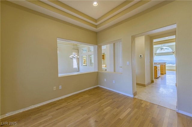 2212 Sierra Heights Dr, Las Vegas, NV 89134 - empty room with light wood finished floors, baseboards, and a notable chandelier