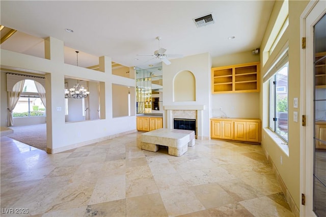 2212 Sierra Heights Dr, Las Vegas, NV 89134 - unfurnished living room featuring ceiling fan with notable chandelier, baseboards, a premium fireplace, and visible vents