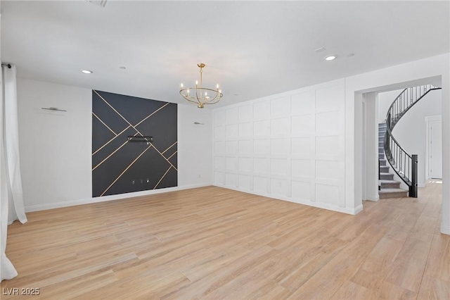 spare room featuring stairway, recessed lighting, light wood finished floors, baseboards, and a notable chandelier