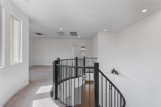 hallway featuring visible vents, baseboards, an upstairs landing, carpet, and recessed lighting