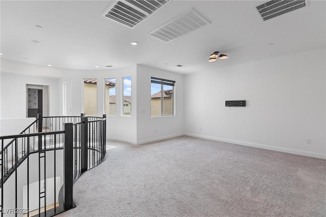 spare room with baseboards, visible vents, and carpet floors
