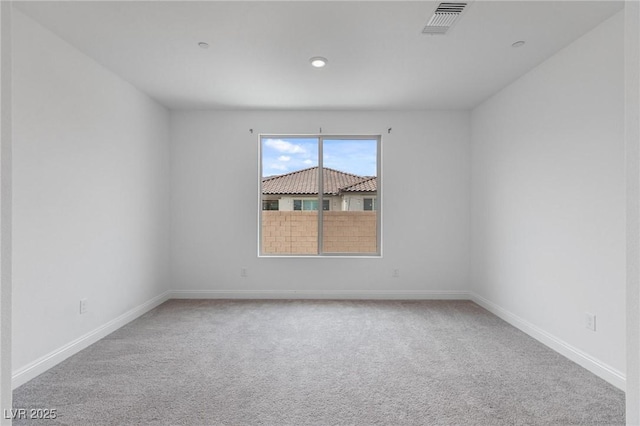 carpeted empty room with visible vents and baseboards