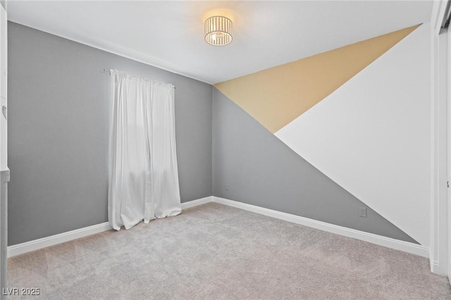 unfurnished room featuring baseboards, lofted ceiling, and carpet floors