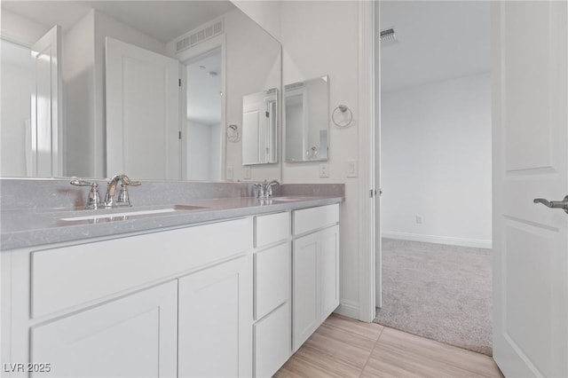 full bath featuring double vanity, a sink, and visible vents