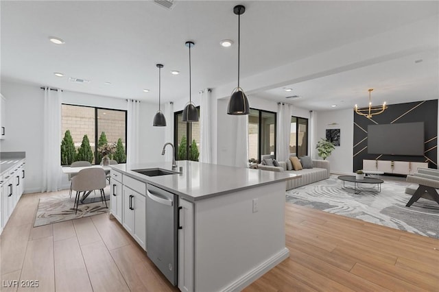 kitchen featuring a chandelier, white cabinetry, light wood finished floors, dishwasher, and a sink