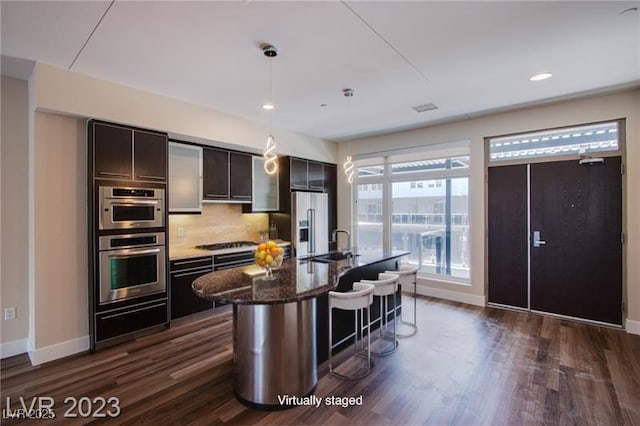8925 W Flamingo Rd Unit 228, Las Vegas, NV 89147 - kitchen featuring a breakfast bar, stainless steel appliances, tasteful backsplash, a sink, and a warming drawer