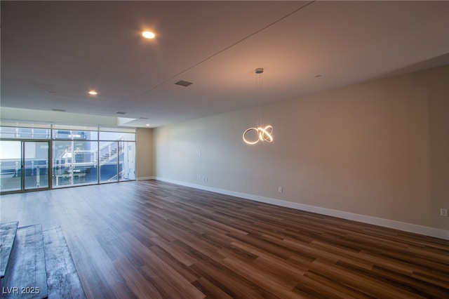 8925 W Flamingo Rd Unit 228, Las Vegas, NV 89147 - empty room featuring baseboards, visible vents, a notable chandelier, and dark wood finished floors