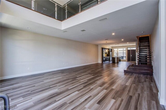 8925 W Flamingo Rd Unit 228, Las Vegas, NV 89147 - unfurnished living room with stairway, wood finished floors, baseboards, visible vents, and recessed lighting