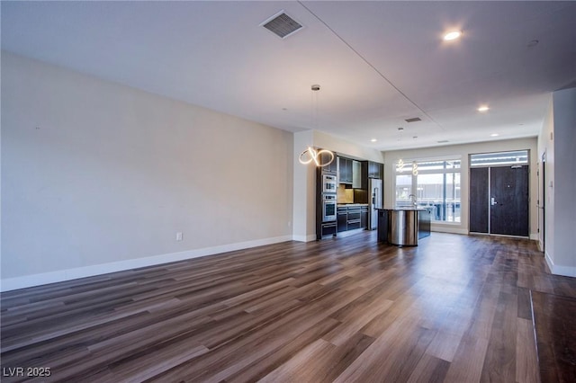 8925 W Flamingo Rd Unit 228, Las Vegas, NV 89147 - unfurnished living room featuring baseboards, visible vents, recessed lighting, and dark wood-type flooring
