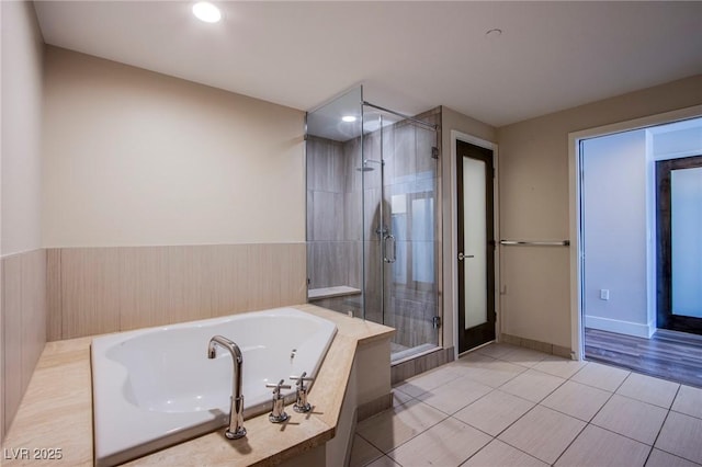 8925 W Flamingo Rd Unit 228, Las Vegas, NV 89147 - bathroom featuring baseboards, a garden tub, tile patterned floors, and a shower stall