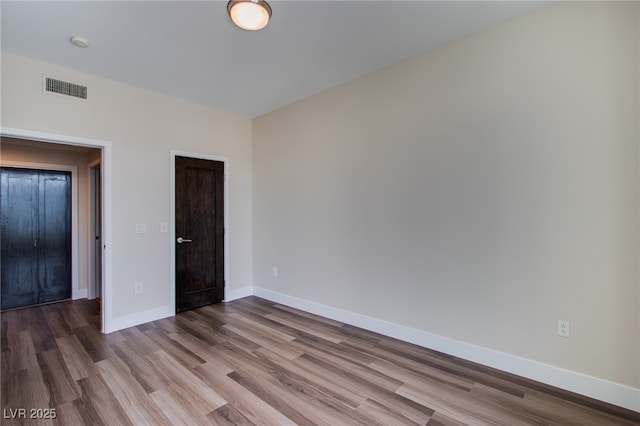 8925 W Flamingo Rd Unit 228, Las Vegas, NV 89147 - unfurnished bedroom featuring baseboards, visible vents, and wood finished floors