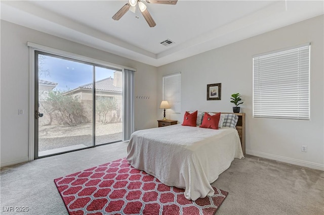 bedroom featuring a tray ceiling, visible vents, access to exterior, carpet flooring, and baseboards