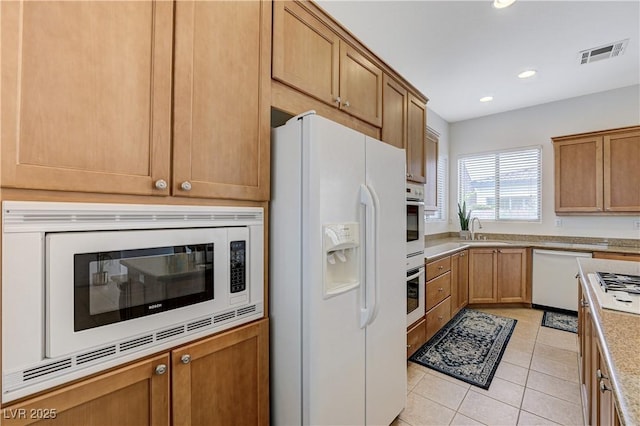 kitchen with recessed lighting, white appliances, light tile patterned floors, visible vents, and a sink