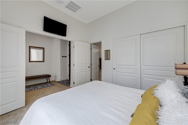 bedroom featuring a closet, light tile patterned floors, and visible vents