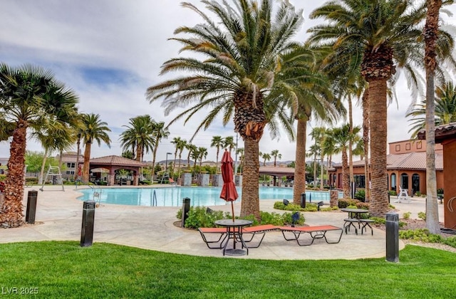 community pool with a patio and a lawn