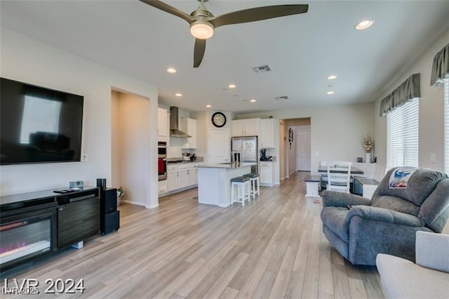 living area with recessed lighting, baseboards, light wood finished floors, visible vents, and a ceiling fan